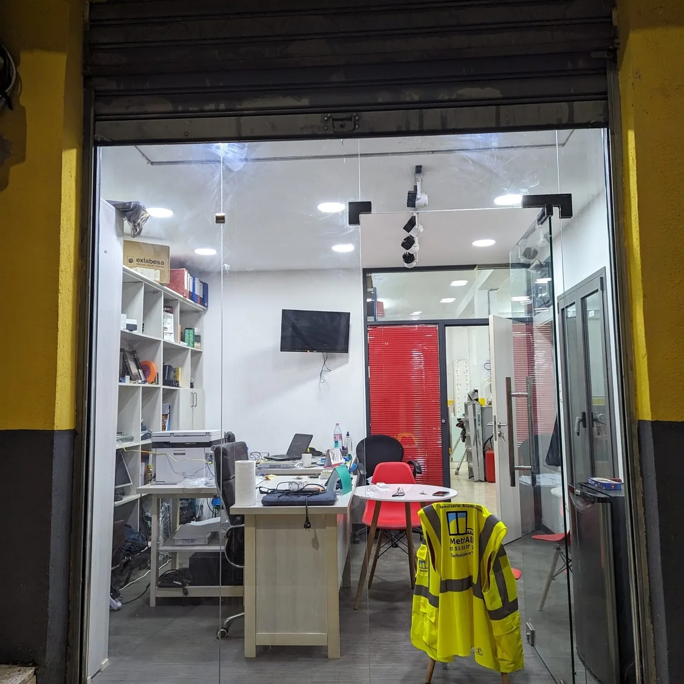 La vitrine de l&rsquo;atelier Metralf à Alger&nbsp;: bureau, établis et profilés visibles derrière la vitre