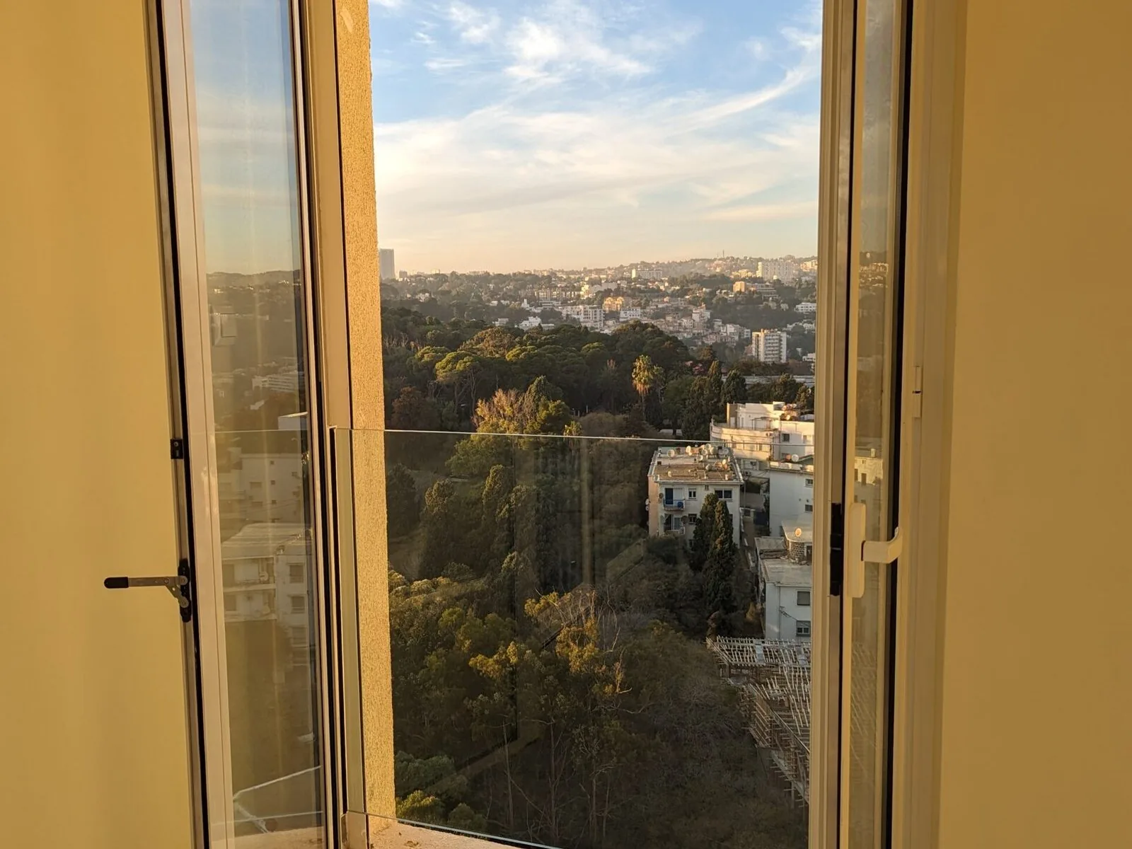 Porte vitrée en aluminium posée par Metralf, ouverte sur la ville