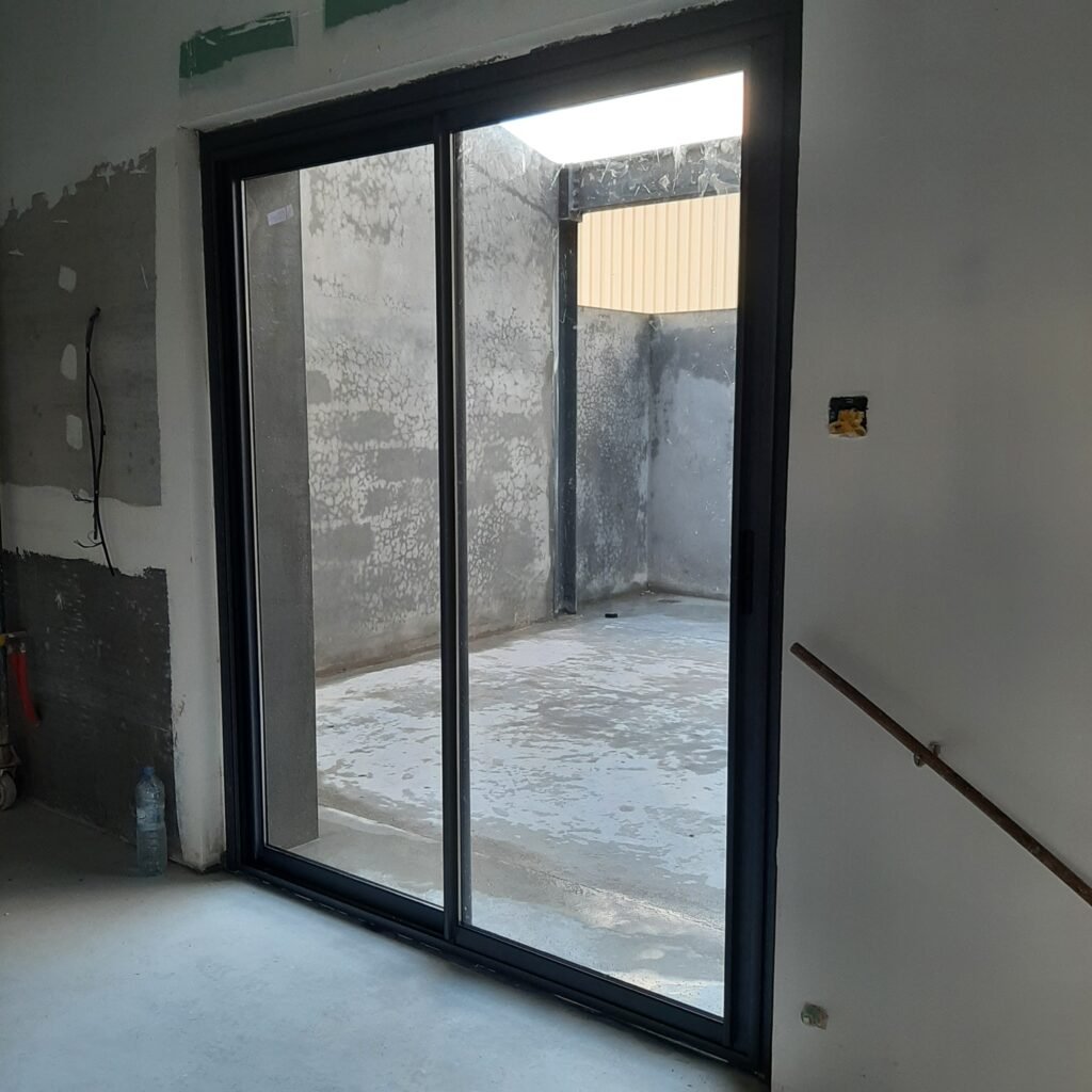 Porte-fenêtre coulissante en aluminium posée par Metralf, chantier en cours