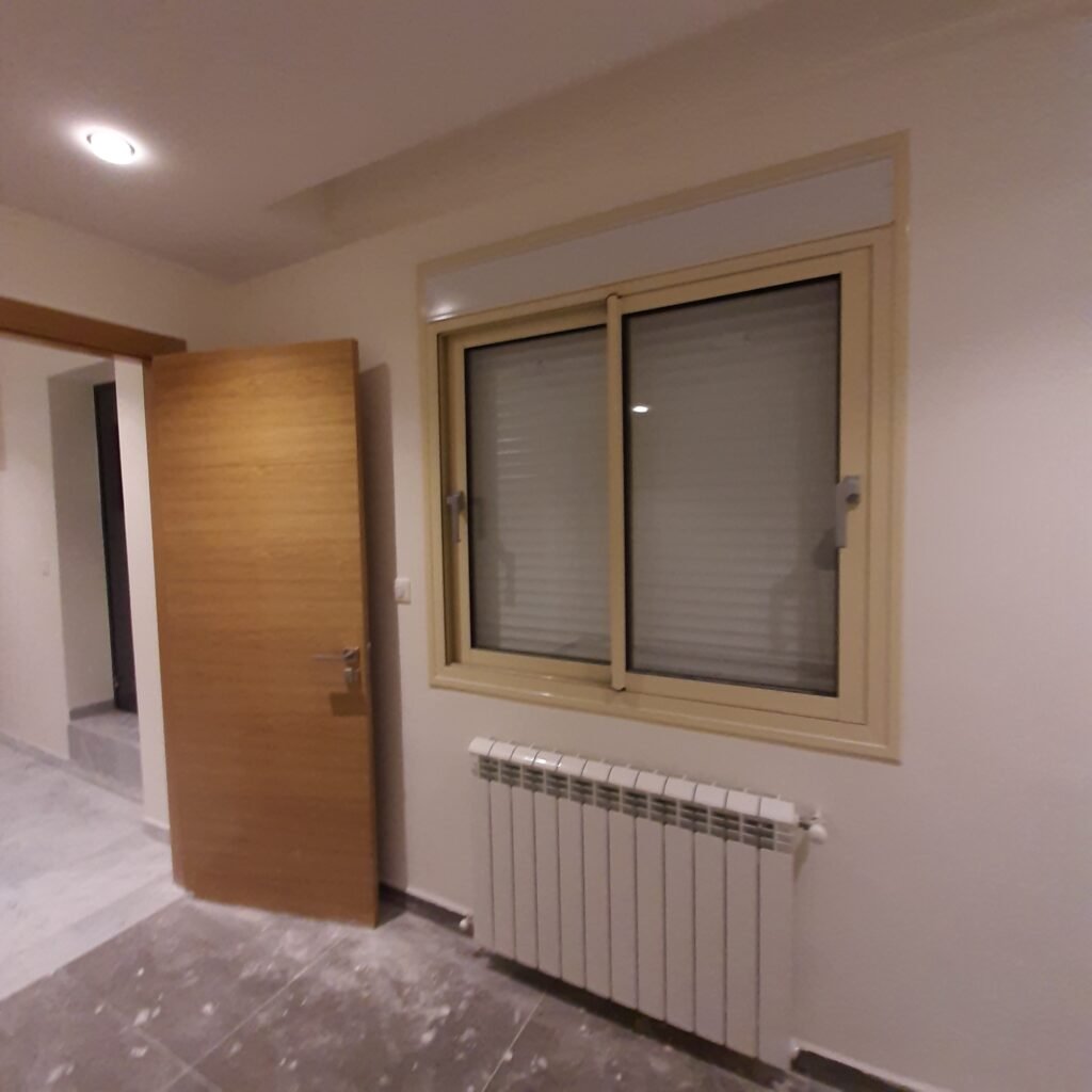 Fenêtre en aluminium avec volet roulant posée par Metralf dans une chambre