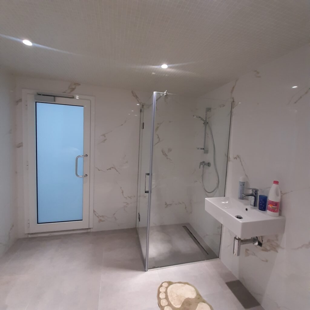Porte en aluminium et paroi de douche en verre posées par Metralf